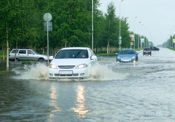 Автомобілі перетинають величезну калюжу на вулиці міста . — стокове фото