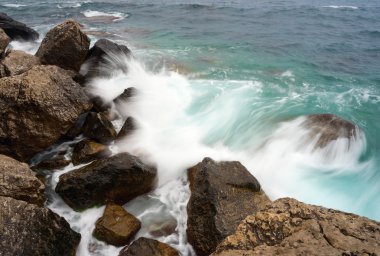 Taşlı bir kıyıda kırma dalgalar deniz