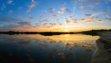 Bulutlar su üzerinde günbatımında sinek..
