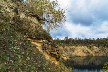 Sonbaharda bir dağ gölünün kumlu kıyısı. Leningrad bölgesi..