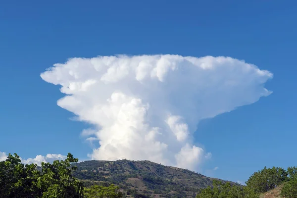 A large white cloud in the shape of a mushroom over the mountains. Crimea. Choban-kule