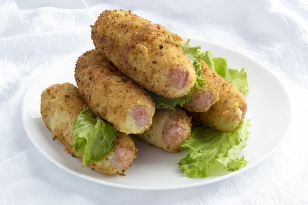 Sausages in mashed potatoes with breadcrumbs. — Stock Photo, Image