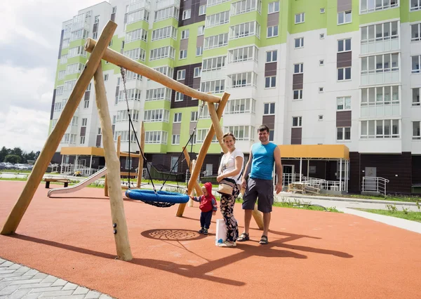 Glad familj stående i gården av ett nytt hem — Stockfoto