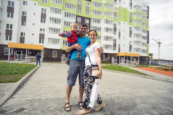 Glad familj stående i gården av ett nytt hem — Stockfoto