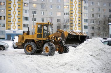 Traktör kürek kar bir yığın avlu.