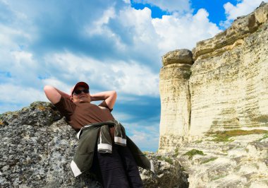 yüksek kayalıklarla yakınındaki taş yatan kadın 