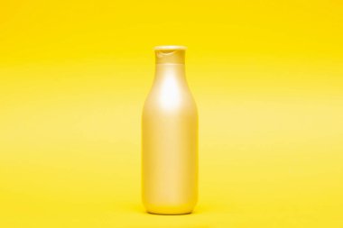 Sarı arka planda şampuan ve saç kremi şişesi, saç bakımı ve tedavi ürünü