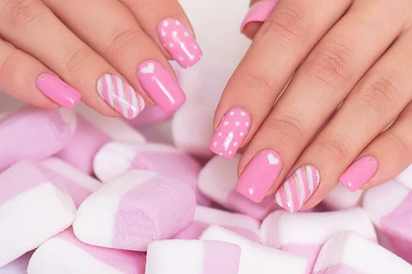 粉红指甲的女性手 棉花糖背景的心脏设计 — 图库照片