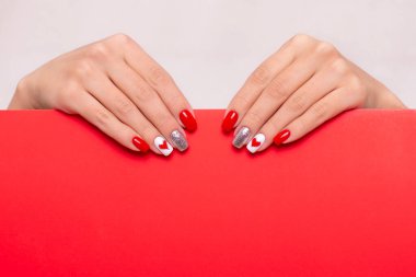 Güzel kadın elleri, şık manikür tırnakları, kırmızı jel cilası, kalp ve sevgililer günü tasarımı, metin için yeri olan.