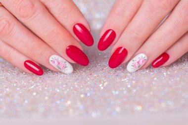 Romantik manikür tırnakları, pembe jöle cilası, şakayık çiçekleri tasarımı olan güzel kadın ellerinin yakın görüntüsü