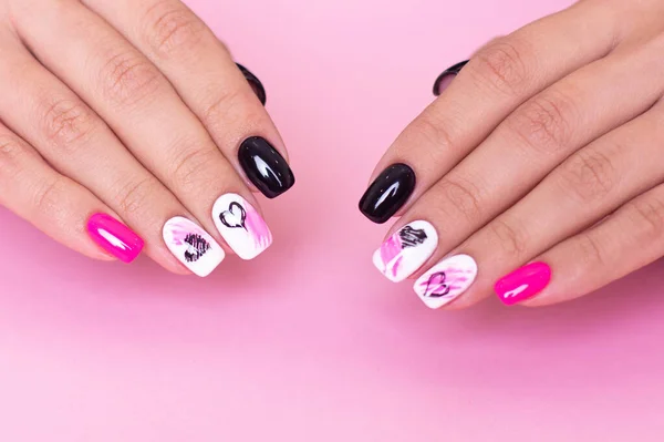 Beautiful female hands with fashion manicure nails, hearts and Valentine\'s day design, on pink background