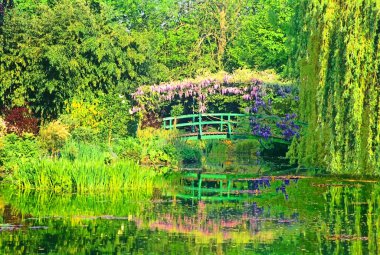 The green Japanese bridge reflecting in the water lily pond, in Claude Monet's Garden of Giverny, Normandy, France clipart