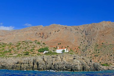 Withe Şapeli (Sotiros Christou), Loutro, Güney Girit Adası yakınlarındaki kayalıklardan ve kuru bitki örtüsünden görüldü.  