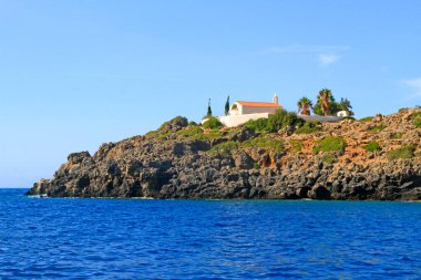 Loutro ve Sougia, Güney Girit adası yakınlarındaki tepeler ve kuru bitki örtüsü ile denizden görülen şapel ve bulut gölgesi  