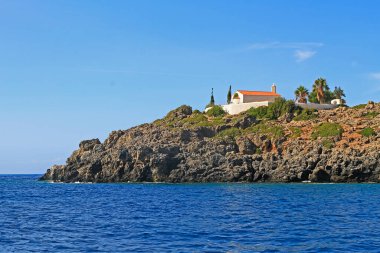 Loutro ve Sougia, Güney Girit adası yakınlarındaki tepeler ve kuru bitki örtüsü ile denizden görülen şapel ve bulut gölgesi  
