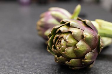 Esmer arka planda taze enginar çiçeği. Organik sağlıklı enginar.