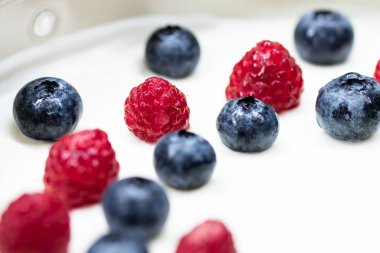 Kremalı beyaz katlı peynirli kek, çilek ve ahududu. Evde yemek pişirmek. Pasta ve fırınla yemek tarifi ve etkinliği. Meyveli cheesecake