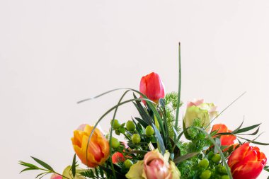 Beyaz arka planda bahar çiçeği buketi. Renkli bir çiçek süslemesi. Çiçek buketinde laleler ve güller