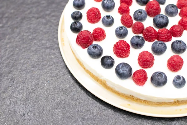 Cheese cake strawberry and raspberry on creamy white flat layer. Cooking at home. Recipe and cooking activity with pastry and bakery. Cheesecake with fruits