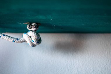 Bir denizci mavi tahta blokta düğümleniyor. Deniz ve denizci kavramı