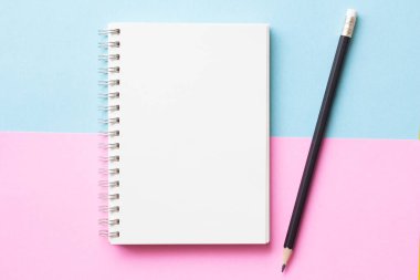 Pastel mavi ve pembe arkaplanlı düz defter yatağı, minimal stil. Çalışma alanı ikili tonu.