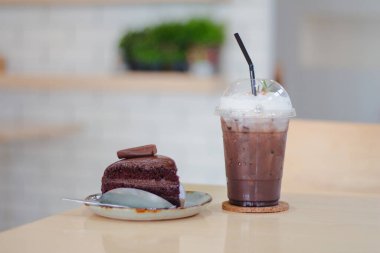 Tahta masa üzerinde soğuk çikolata ve beyaz arka planlı çikolatalı pasta..