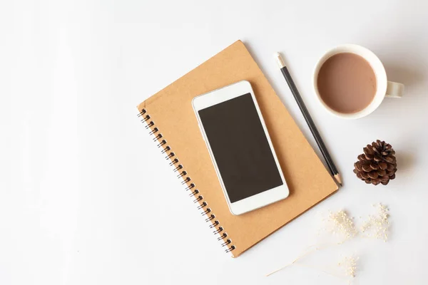 Akıllı telefon, defter, kalem, kahve ve fotokopi arkaplanı olan kuru çam kozalaklı ofis masasının düz bir fotoğrafı..