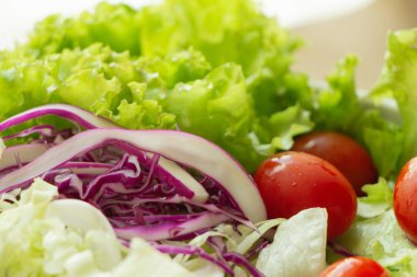 Bir kase sebze salatası, kiraz domatesleri, kırmızı lahana, marul. Sağlıklı yiyecek..