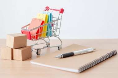 Tramvayda ya da alışveriş arabasında karton olan renkli kağıt alışveriş torbaları, e-ticaret konsepti..