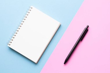 Pastel mavi ve pembe arkaplanlı düz defter yatağı, minimal stil. Çalışma alanı ikili tonu.