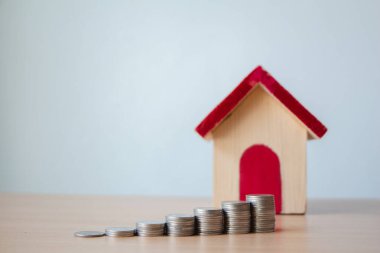 Masada ahşap ev kırmızı çatılı para yığını. Emlak yatırımı gayrimenkul ve ev kredisi finansal konsepti.,