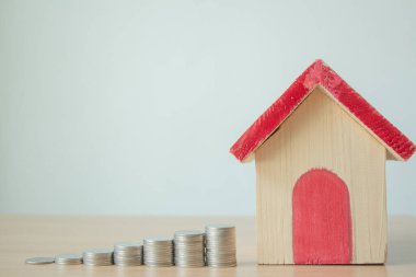Masada ahşap ev kırmızı çatılı para yığını. Emlak yatırımı gayrimenkul ve ev kredisi finansal konsepti.,