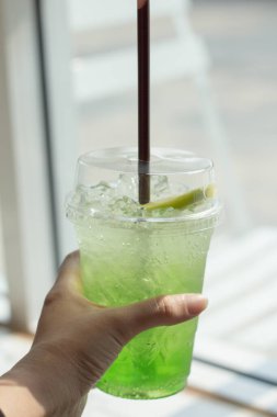 Kivi İtalyan Sodası cam pencerenin yanındaki mermer masada..