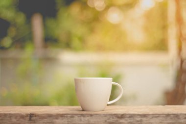 Sabah güneşinde masada bir fincan sıcak kahve..