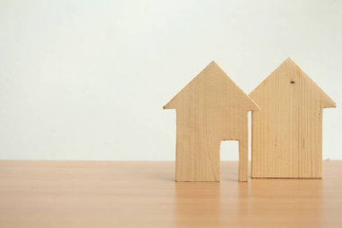 Beyaz arka planda ahşap ev modeli, doğru gayrimenkul ya da toplu konut inşaatında yeni ev seçimi