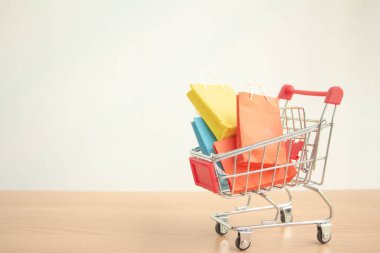 Tramvayda ya da alışveriş arabasında renkli kağıt alışveriş torbaları. E-ticaret konsepti..