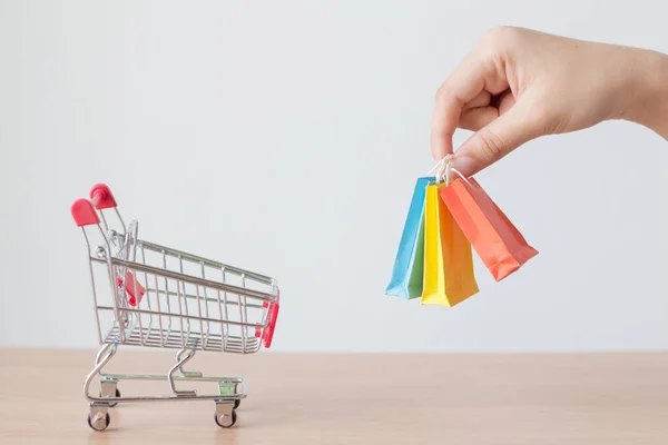 Manos Mujer Sosteniendo Una Pequeña Bolsa Compras Con Carrito Compras —  Fotos de Stock