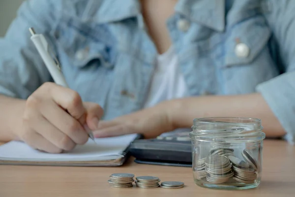 Гроші Скляній Банці Калькулятором Жіночою Рукою Пишуть Блокноті — стокове фото