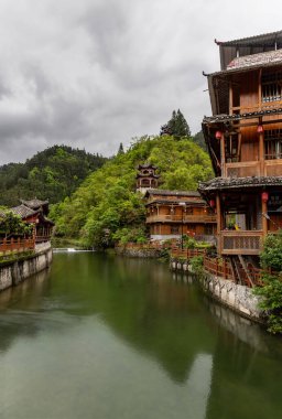 a vertical closeup shot of a waterfall in a green forest,Miao Village Scenery in Libo, Guizhou, China