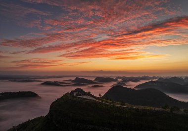 Shangsi Town, Dushan County, Guizhou, Çin 'deki karst tepeleri üzerinde gün doğumu ve bulutlar denizi.