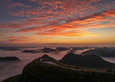 Shangsi Town, Dushan County, Guizhou, Çin 'deki karst tepeleri üzerinde gün doğumu ve bulutlar denizi.