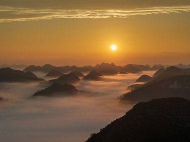 Shangsi Town, Dushan County, Guizhou, Çin 'deki karst tepeleri üzerinde gün doğumu ve bulutlar denizi.
