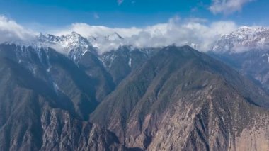 Lancang Nehri Kanyonu 'nun ve Quzika Kasabası, Mangkang Bölgesi, Tibet, Çin' deki karla kaplı dağların hızlandırılmış hava görüntüleri..