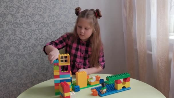 Ett Barn Flicka Leker Vid Bordet Med Konstruktör Gjord Färgglada — Stockvideo