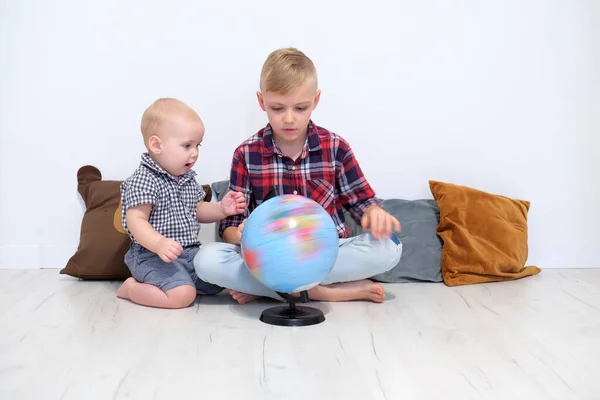 Bratři Chlapci Hrají Glóbem Starší Bratr Otáčí Zeměkoulí Ukazuje Dítěti — Stock fotografie