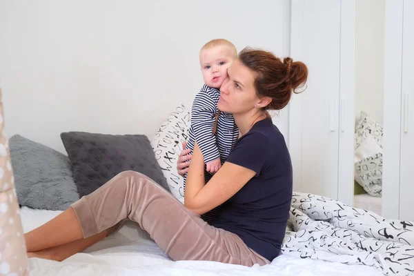 累了的妈妈在卧室的床上抱着古怪的蹒跚学步的托德勒 妈妈试着让一个哭哭啼啼的婴儿入睡 — 图库照片