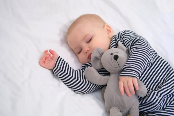 一个睡梦中的婴儿 他最喜欢穿着条纹睡衣的软玩具鼠标 选择性聚焦 — 图库照片