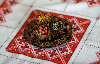 Renkli paskalya yumurtalarıyla geleneksel Ukrayna Slav tasarımlarının karışımı. Geleneksel işlemeli masa örtüsü vyshyvanka üzerinde el yapımı güzel Ukraynalı geleneksel bir tabak. Seçici odak