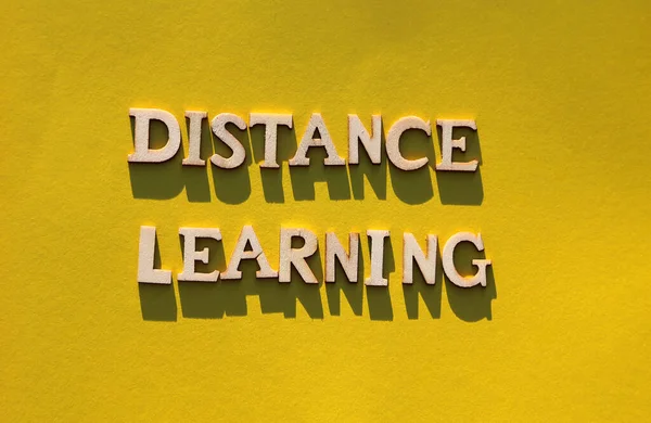 语言远程学习 黄色背景上有字母加长长的阴影的木制字母 在线学习概念 — 图库照片