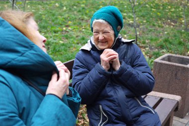 İki yaşlı bayan, anne ve kız, bir sonbahar günü parkta yürüyor, konuşuyor ve gülüyorlar..